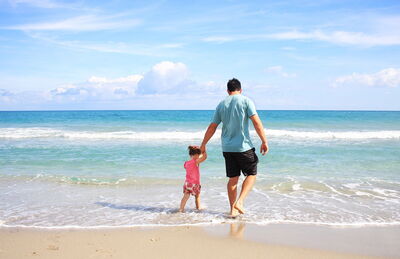 Père et fille sur une plage