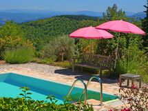 Under the umbrella , near the pool, the view behind you...a book in your hand..